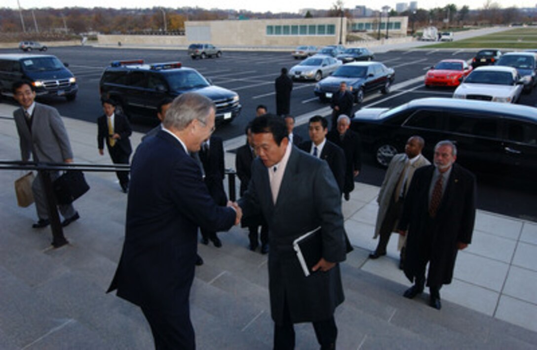 Secretary of Defense Donald H. Rumsfeld greets Japan's Minister of Foreign Affairs Taro Aso as he arrives at the Pentagon in Arlington, Va., on Dec. 3, 2005. Rumsfeld hosted Aso for a meeting to discuss U.S.-Japan bilateral security issues. 