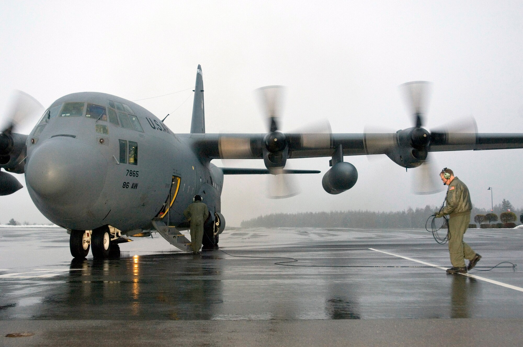 GRAFENWOEHR, Germany (AFPN) -- Master Sgt. Bill Gatzmer gathers his communications cable before reboarding his C-130 Hercules. Sergeant Gatzmer was one of two loadmasters on the mission to transport Romanian soldiers and their gear to Grafenwoehr, Germany, for training. He is with the 37th Airlift Squadron at Ramstein Air Base, Germany. (U.S. Air Force photo by Master Sgt. John E. Lasky)