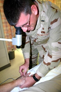 LACKLAND AIR FORCE BASE, Texas (AFPN) -- 1st Lt. Keith Schultz uses an infrared light source to illuminate a patient's hand. The light, placed under a patient's hand, allows medical personnel to see the veins using a monoscope with night vision technology. Lieutenant Schultz is an emergency department nurse with the 59th Medical Wing here. (U.S. Air Force photo by Master Sgt. Kimberly Spencer)
