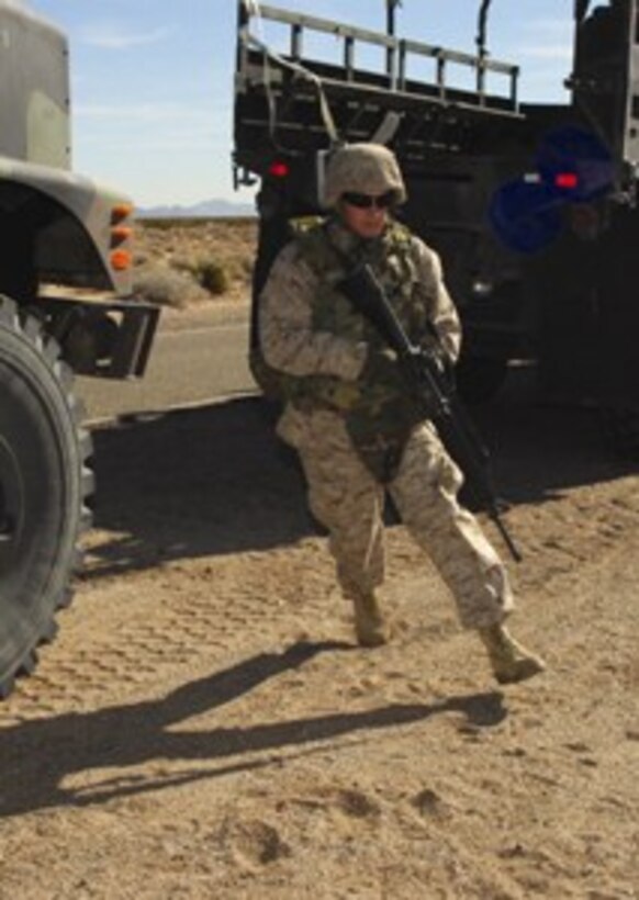 Cpl. Gregory Rust, Marine Air Control Squadron 1 radar repairman and native of Evansville, Ind., practices engaging enemy forces as he runs around a seven-ton truck on a convoy security exercise at the Barry M. Goldwater range located approximately 12 miles south of the air station Dec. 7. The convoy training was a refresher for the Marines before they get deployed next year, and it also gave them a chance to learn many new skills involved with convoy security.