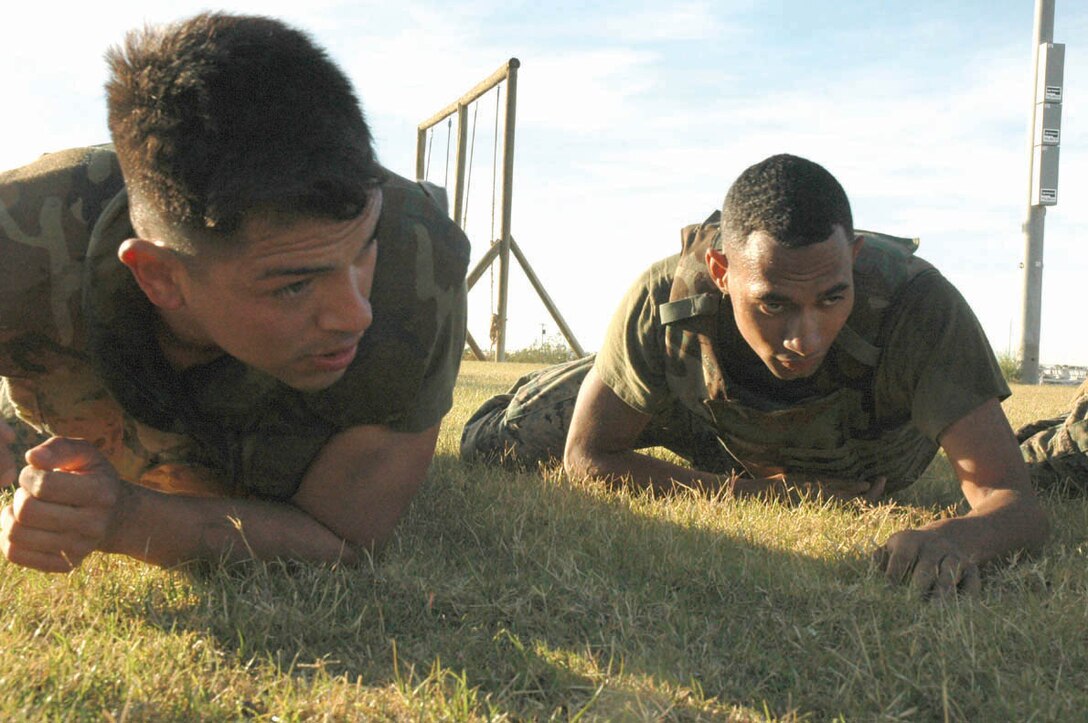 Cpl. Raymond Hazelton (left), Headquarters and Headquarters Squadron Aircraft Rescue Fire Fighting senior rescueman and native of South Euclid, Ohio, and Cpl. Dedrick McDannell, Marine Aviation Logistics Squadron 13 micro miniature electrician and native of Onley, Va., crawl across Ramada Field here Dec. 7 as part of a martial arts instructor training course. The course is very physically demanding, with Marines doing combat conditioning exercises several times a week, on top of the physical training they already do. In addition to the physical training, Marines are also taught mental and character strength so they may pass it on to the Marines they will train in the Marine Corps Martial Arts Program.