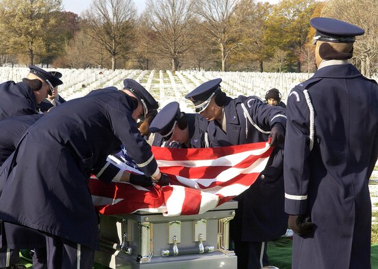 ARLINGTON NATIONAL CEMETERY, Va. (AFPN) -- U.S. Air Force Honor Guard pallbearers place the remains of Col. Wilfred B. Crutchfield and Lt. Col. Ivan E. O'Dell at their gravesite in Arlington National Cemetery. The remains were laid to rest with full military honors here, Dec. 7. The Airmen died in a plane crash in 1968 but their remains were not discovered until October 2004. (U.S. Air Force photo by Thomas Dennis) 