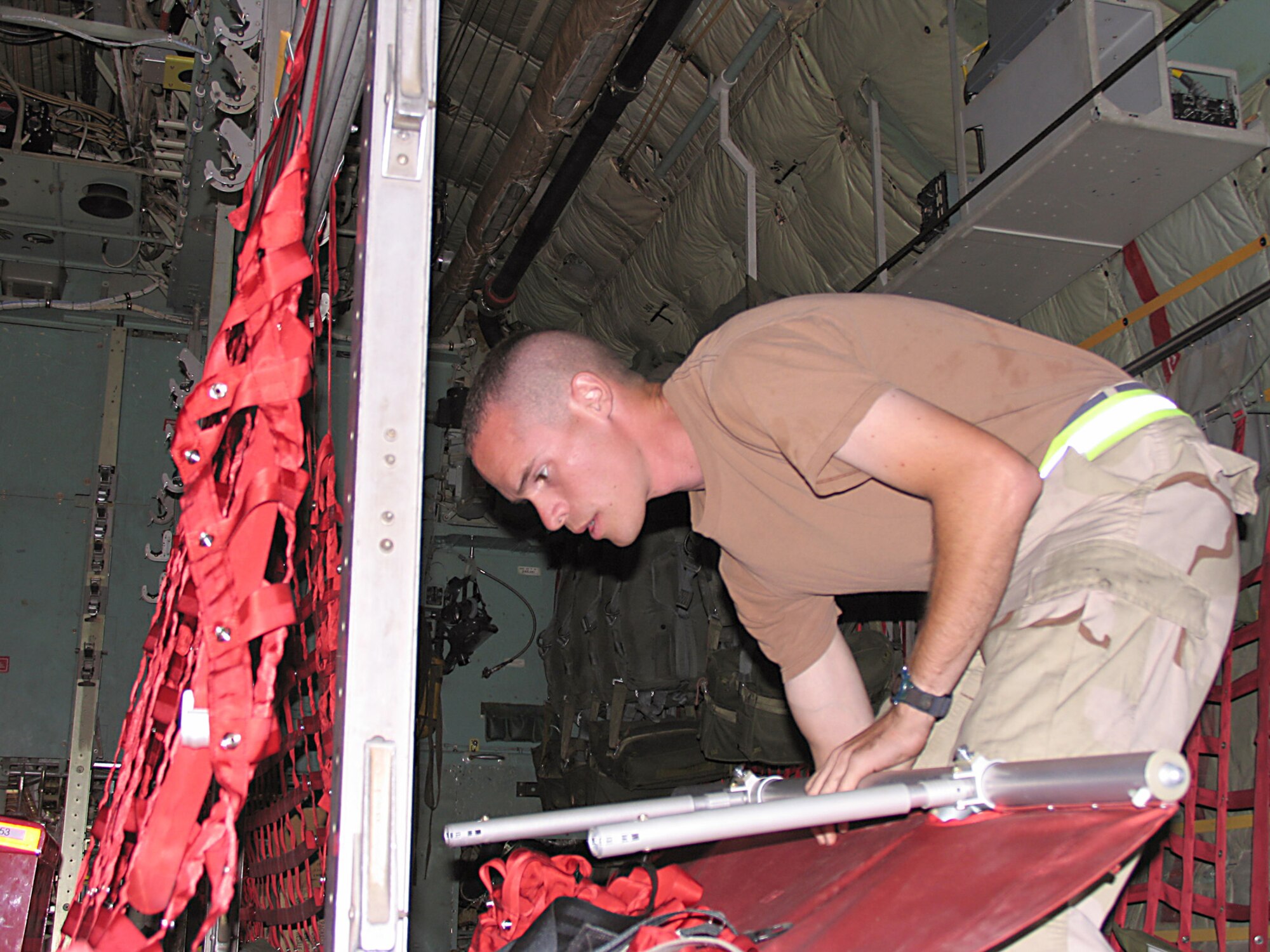 SOUTHWEST ASIA (AFPN) -- Senior Airman Chadwick Moore breaks down seating inside a C-130 Hercules before the next mission. (U.S. Air Force photo by Tech. Sgt. Mark Getsy) 
