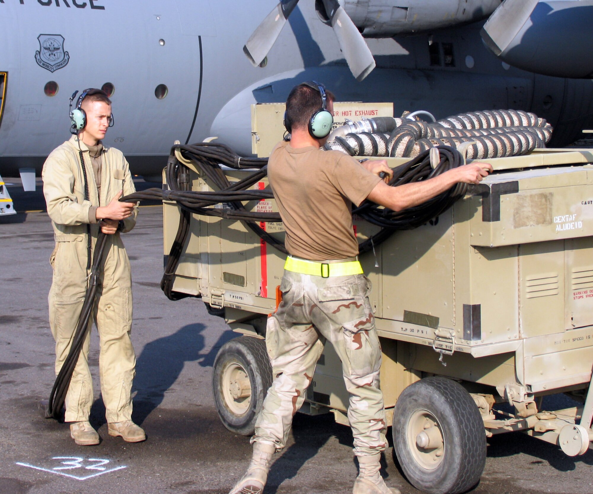 SOUTHWEST ASIA (AFPN) -- Senior Airman Matthew Medley (left) and Senior Airman Johnathan Feucht remove the power unit from a C-130 Hercules before the aircraft taxis on the flightline. Airman Medley and Airman Feucht are both with the 386th Expeditionary Aircraft Maintenance Squadron. (U.S. Air Force photo by Tech. Sgt. Mark Getsy) 