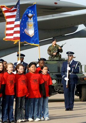 MCCONNELL AIR FORCE BASE, Kan. (AFPN) -- Beech Elementary School students sing "My Country 'Tis of Thee" on the flightline during the taping of the 21st annual World's Largest Concert. The performance held Dec. 2 is scheduled to be broadcast in March on the Public Broadcasting Service and the American Forces Television and Radio Network. The event was sponsored by the National Association for Music Education. (U.S. Air Force photo by Master Sgt. Maurice Hessel)