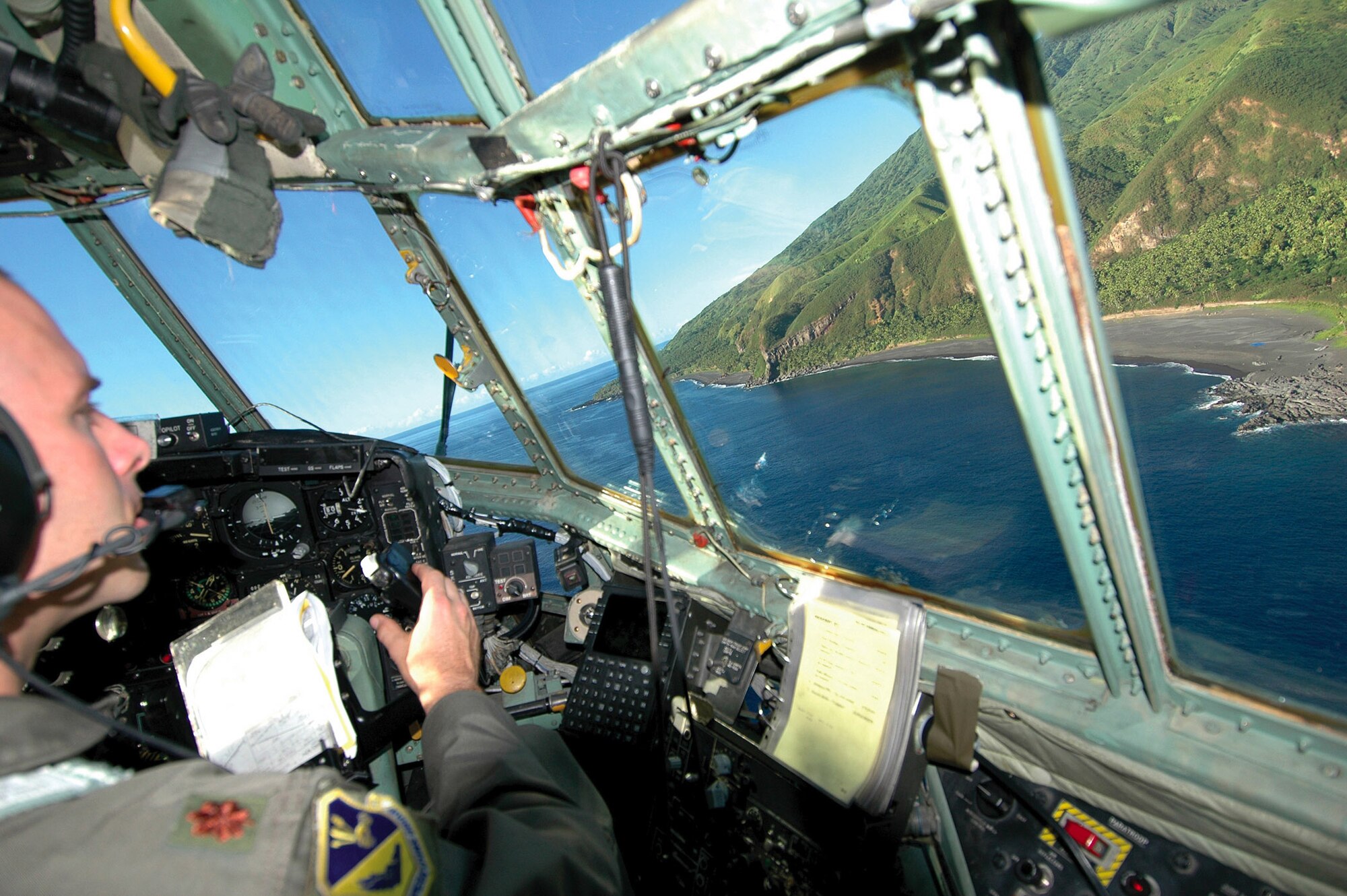 ANDERSEN AIR FORCE BASE, Guam (AFPN) -- Maj. Matt Wehner looks out over the northern Micronesian Island of Agrihan after dropping a pallet of supplies. Airmen from Yokota Air Base, Japan, travel to Andersen each year to airdrop the donated supplies. Major Wehner is a pilot with the 36th Airlift Squadron from Yokota AB. (U.S. Air Force photo by Staff Sgt. Karen J. Tomasik)