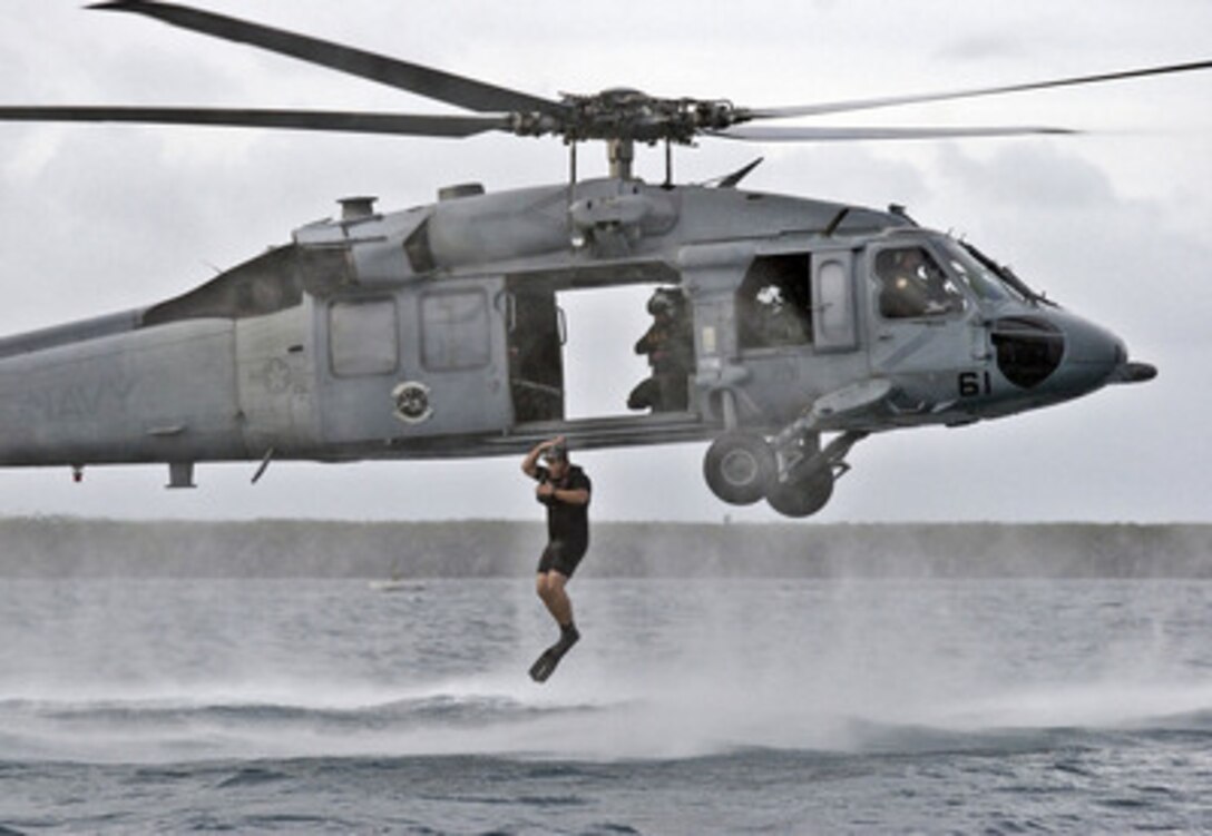 Navy Petty Officer 1st Class Eric Sutton jumps into the Pacific Ocean from a hovering MH-60S Seahawk helicopter during a search and rescue training exercise off the coast of Guam on Dec. 8, 2005. Sutton, a Navy aviation machinist's mate, is a search and rescue swimmer attached to Helicopter Sea Combat Squadron 25 deployed to Anderson Air Force Base, Guam. 