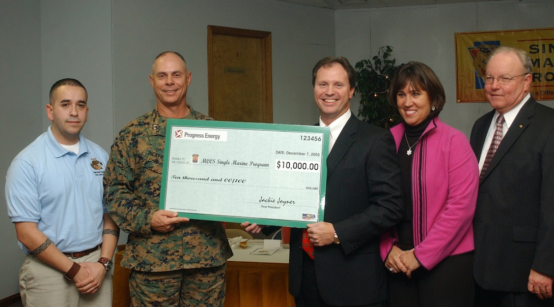 MARINE CORPS BASE CAMP LEJEUNE, N.C. - Jackie Joyner, the east regional vice-president for Progress Energy, and Dan Oliver, the community relations manager for Progress Energy, presented Sgt. Juan S. Vargas Jr., the Camp Lejeune Single Marine Program president, Maj. Gen. Robert C. Dickerson, the commanding general for Marine Corps Installations East, and Susan D. Goodrich, the coordinator of the Camp Lejeune Single Marine Program, with a check for $10,000 from Progress Energy at the inaugural "Steak" Your Claim dinner Wednesday. The money will be put toward funding for upcoming Single Marine Program activities and events. Photo by Lance Cpl. Adam Johnston