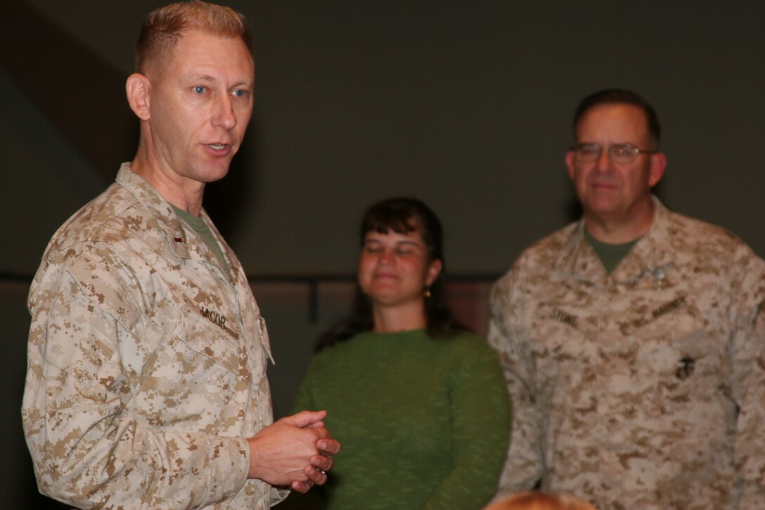 Chief Warrant Officer 5 Robert C. Jacob III, Marine Corps Air Ground Combat Center Band officer, joined by his wife, Anne, and Brig. Gen. Douglas M. Stone, Combat Center commanding general, speaks to his Marine musicians at the base theater shortly after being promoted Dec. 9 at the base theater.