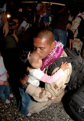 48th Aerial Port Squadron Reservist, SrA Elbert Tejano, returns home after a one-year assignment in Iraq, Monday at the Honolulu Airport and receives a warm welcome from his wife, Jeraldine and 2 year old twins Elena (pictured) and Janelle. (Air Force Photo by Angela Elbern)