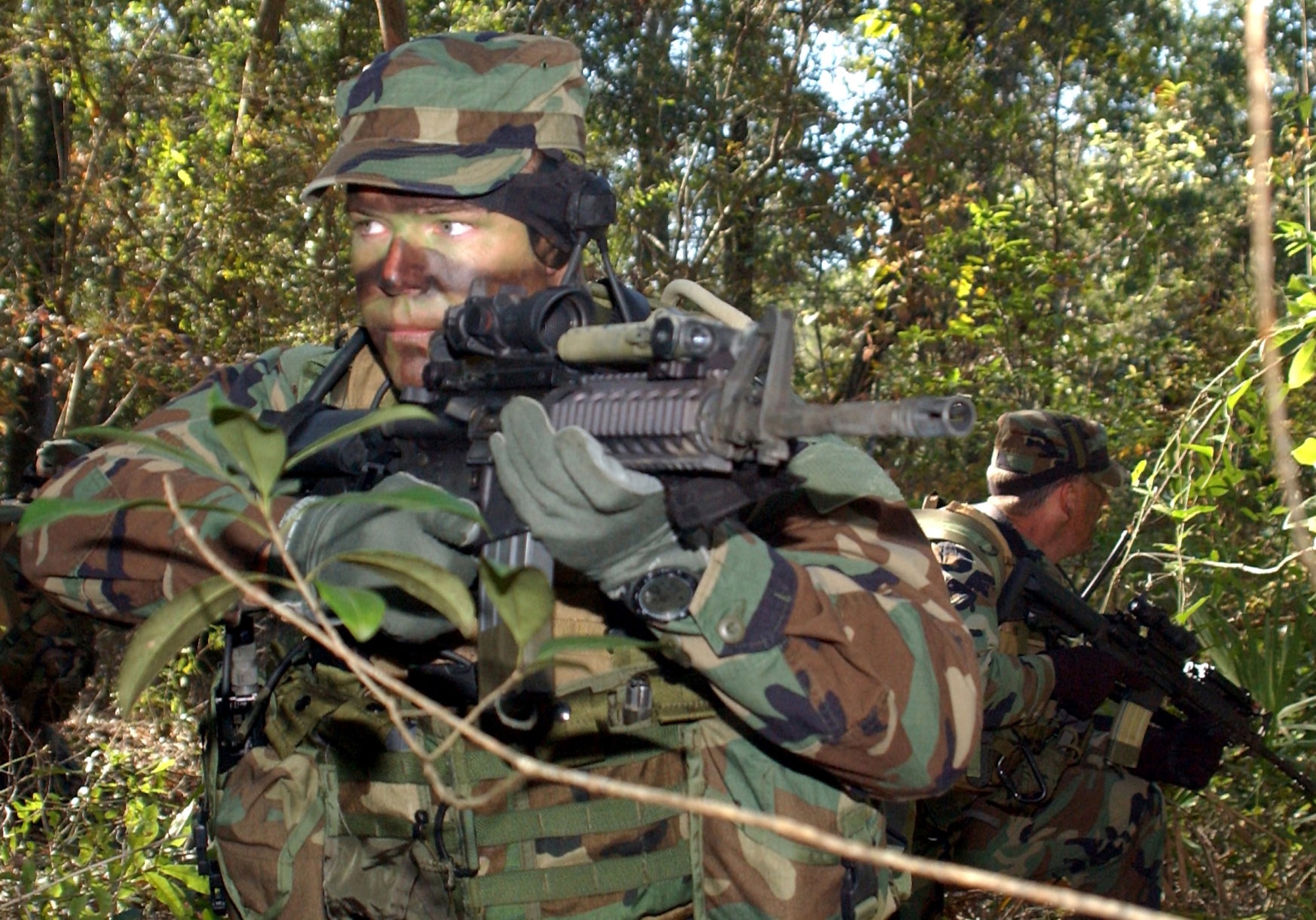 HURLBURT FIELD, Fla. (AFPN) -- Capt. Don Garrett (left) and Staff Sgt. Jody Ball look for enemy forces during a special operations weather team exercise near the base. Special operations weathermen are highly trained to operate in hostile environments with special operators from all services. They provide weather data and forecasts that combatant commanders need to plan and execute missions. Captain Garrett and Sergeant Ball are with the 10th Combat Weather Squadron here. (U.S. Air Force photo by Chief Master Sgt. Gary Emery) 