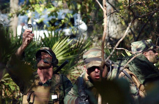 HURLBURT FIELD, Fla. (AFPN) -- Tech. Sgt. Rick Rohde (left) takes a wind velocity reading while Staff Sgt. Jody Ball (center) and Tech. Sgt. Jim Morello provide cover during a special operations weather team exercise near the base. The Airmen are with the 10th Combat Weather Squadron here. (U.S. Air Force photo by Chief Master Sgt. Gary Emery) 
