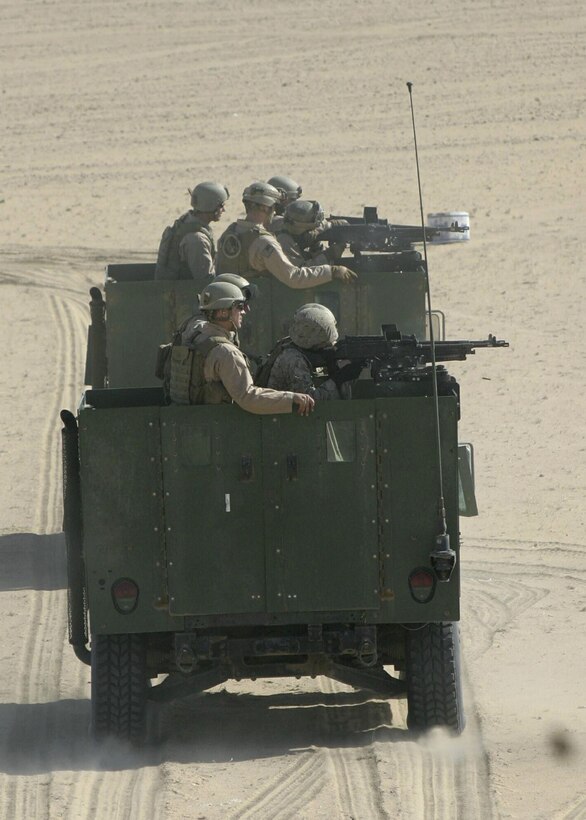 Two highback Humvees filled with Marines from the Maritime Special Purpose Force (MSPF) of the 22nd Marine Expeditionary Unit (Special Operations Capable), practice firing their M240G medium machine guns while on the move during during live fire training on the Udari Range outside Camp Beuhring, Kuwait, Dec. 11, 2005.  The 22nd MEU (SOC) is currently in Iraq conducting combat operations in the Al Anbar province.
