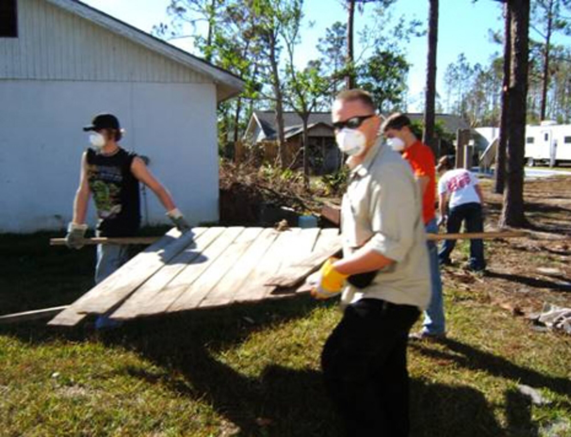 Rob Stewart front, Mike Seidel, left, and Darren Brown spend Thanksgiving Day removing debris left behind from Hurricane Katrina. (Courtesy photo) 