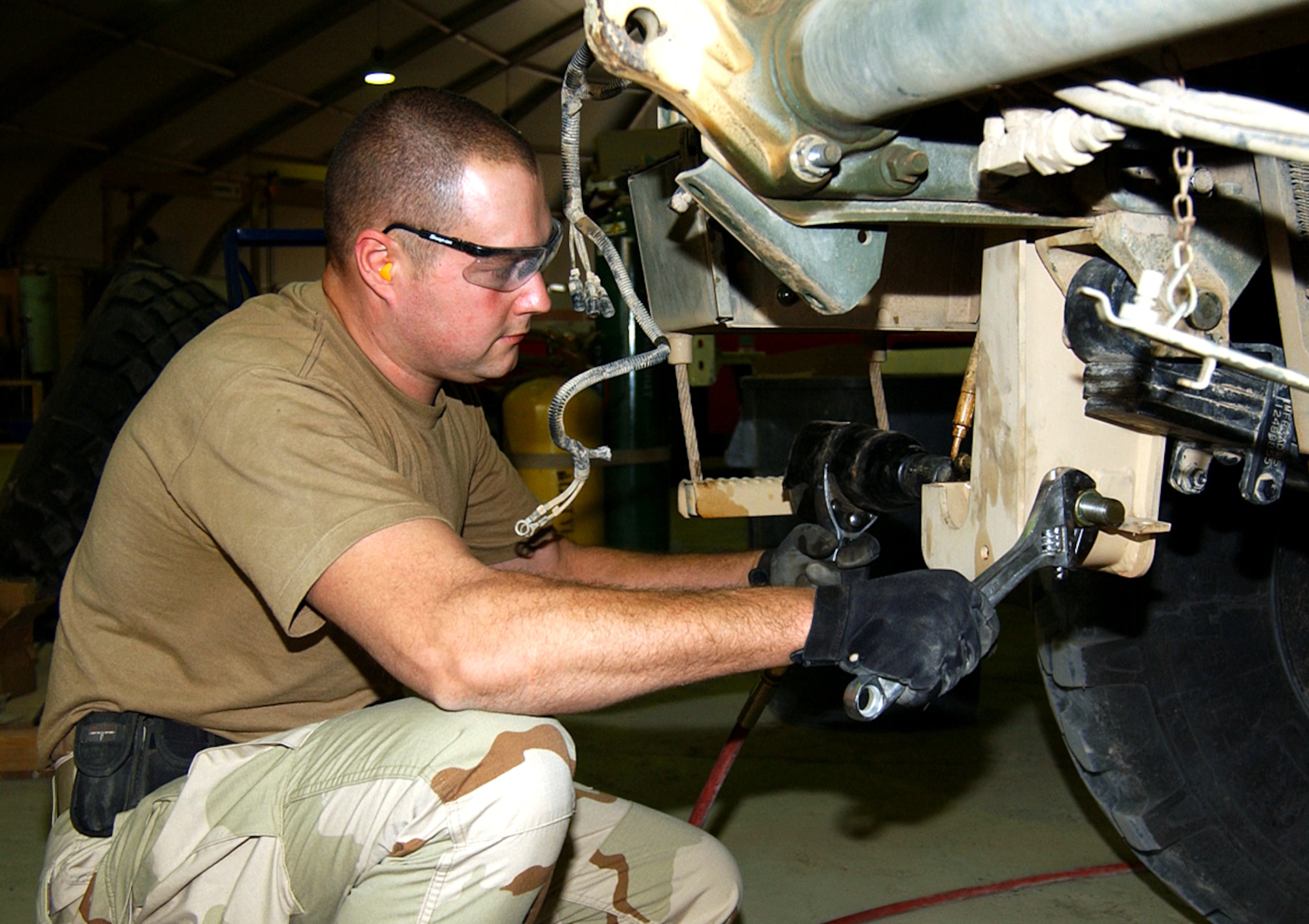 BALAD AIR BASE, Iraq (AFPN) -- Staff Sgt. Jeffrey Arnett installs a heavy duty raising cylinder on a truck. The cylinder helps support the weight of the newly installed armor. Sergeant Arnett is with the 732nd Expeditionary Logistics Readiness Squadron. (U.S. Air Force photo by Staff Sgt. Tammie Moore)