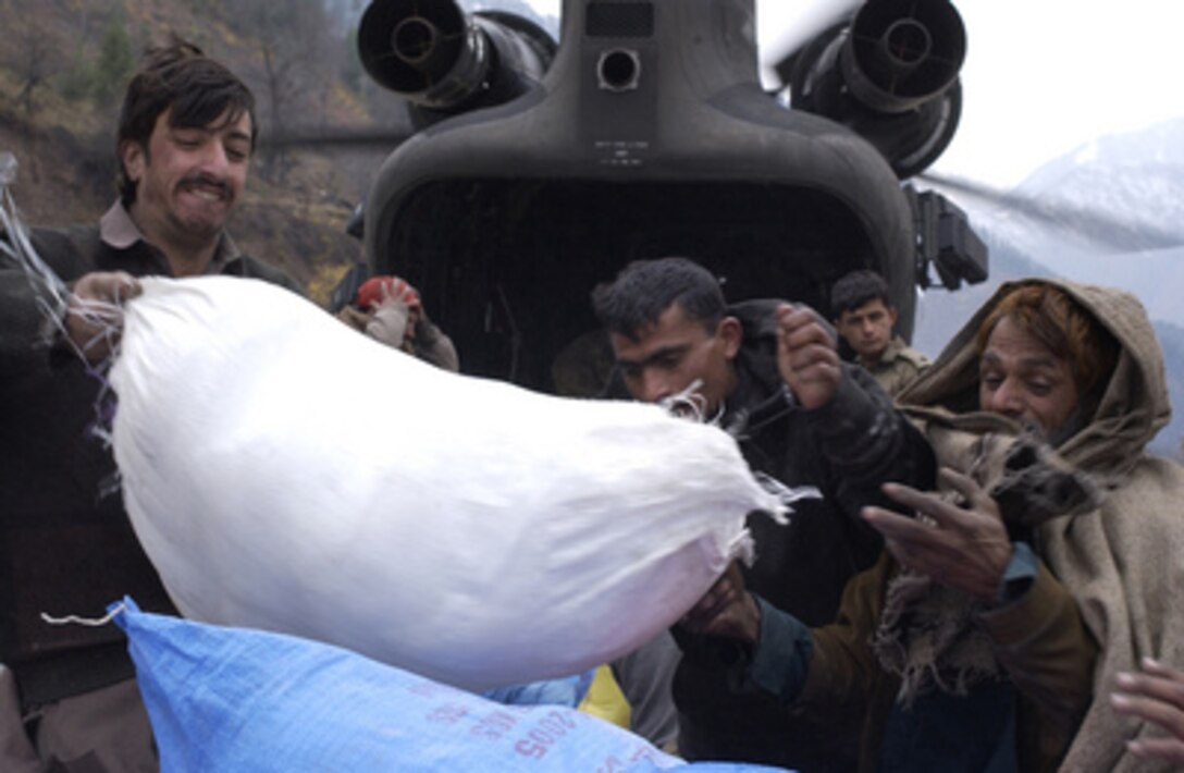 Pakistanis unload humanitarian relief supplies from a U.S. Army CH-47D Chinook helicopter at Bhonja, Pakistan, on Nov. 29, 2005. The Department of Defense is supporting the State Department by providing disaster relief supplies and services following the massive earthquake that struck Pakistan and parts of India and Afghanistan. 