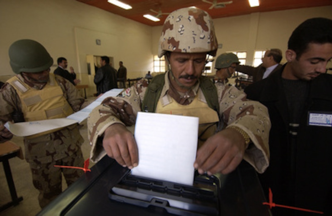 An Iraqi soldier places his completed ballot into the ballot box after voting along with other Iraqi security forces in Hayji, Iraq, on Dec. 12, 2005. Iraqi citizens will be voting on Dec. 15, 2005, to elect Iraq's first free, permanent parliamentary government. 