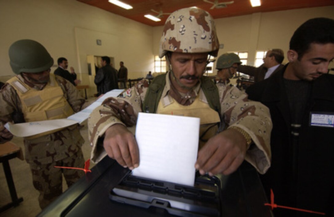 An Iraqi soldier places his completed ballot into the ballot box after voting along with other Iraqi security forces in Hayji, Iraq, on Dec. 12, 2005. Iraqi citizens will be voting on Dec. 15, 2005, to elect Iraq's first free, permanent parliamentary government. 