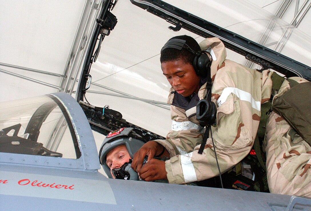 EGLIN AIR FORCE BASE, Fla. — Airman 1st Class Daryle Elams, 60th Aircraft Maintenance Unit crew chief, fastens in Royal Air Force Squadron Leader Mark Chappell, a 60th Fighter Squadron pilot, before his takeoff during the 33rd Fighter Wing’s Phase II exercise in May. (U.S. Air Force photo by Staff Sgt. Jerron Barnett)