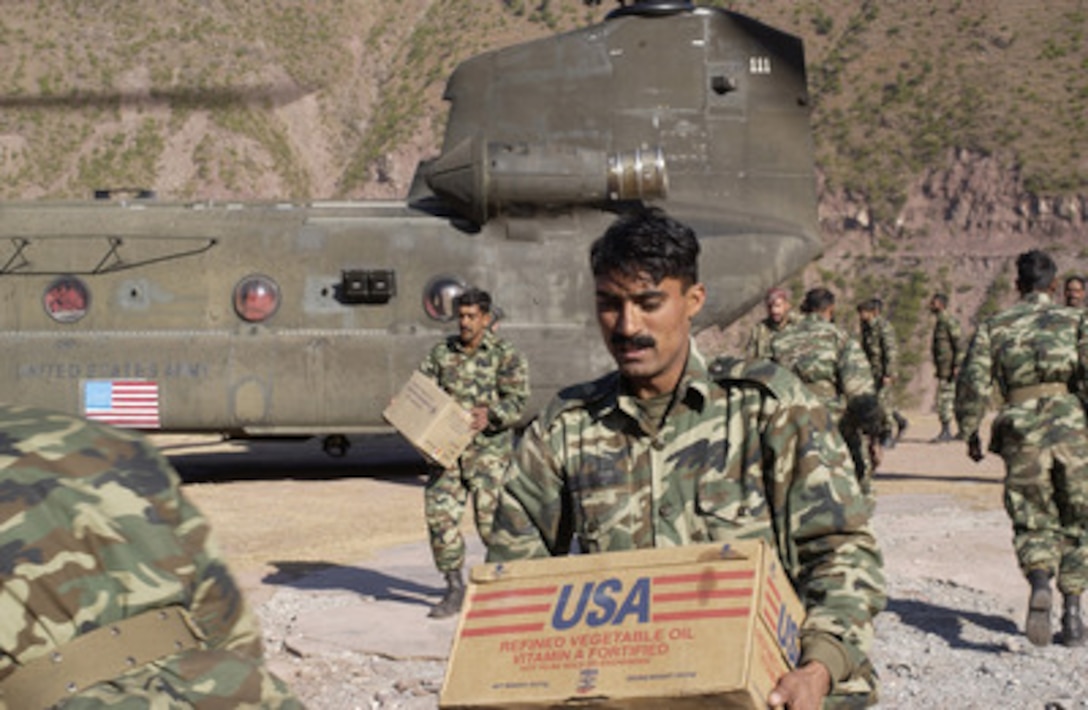Pakistani soldiers unload humanitarian relief supplies from a U.S. Army CH-47D Chinook helicopter in Nardjan, Pakistan, on Dec. 10, 2005. The Department of Defense is supporting the State Department by providing disaster relief supplies and services following the massive earthquake that struck Pakistan and parts of India and Afghanistan. 