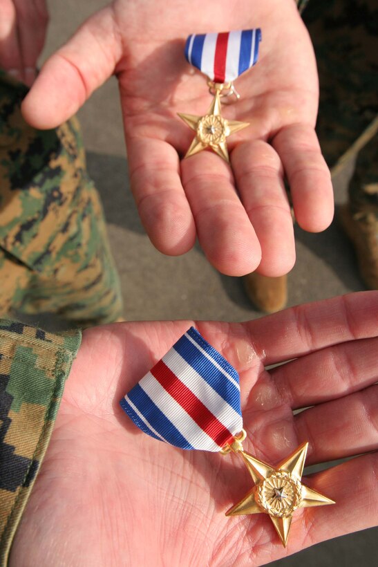 Marine officers Major Robert S. Weiler and Capt. Christopher J. Bronzi display their Silver Star Awards after a ceremony where they both were presented the  honor by 1st Marine Division commanding general Maj. Gen. Richard F. Natonski at Camp Pendleton Dec. 13. The Marine officers from 2nd Battalion , 4th Marines, 5th Marine Regiment received their award for their actions in support of Operation Iraqi Freedom II last year. When isolated and outnumbered, Bronzi commanded his Marines from a rooftop in a deadly assault which contributed to the elimination of 250 insurgents. Weiler led the quick reaction force that aided Bronzi while he was cornered and directed his men on various occasions to counterattack the enemy while facing a barrage of bullets.