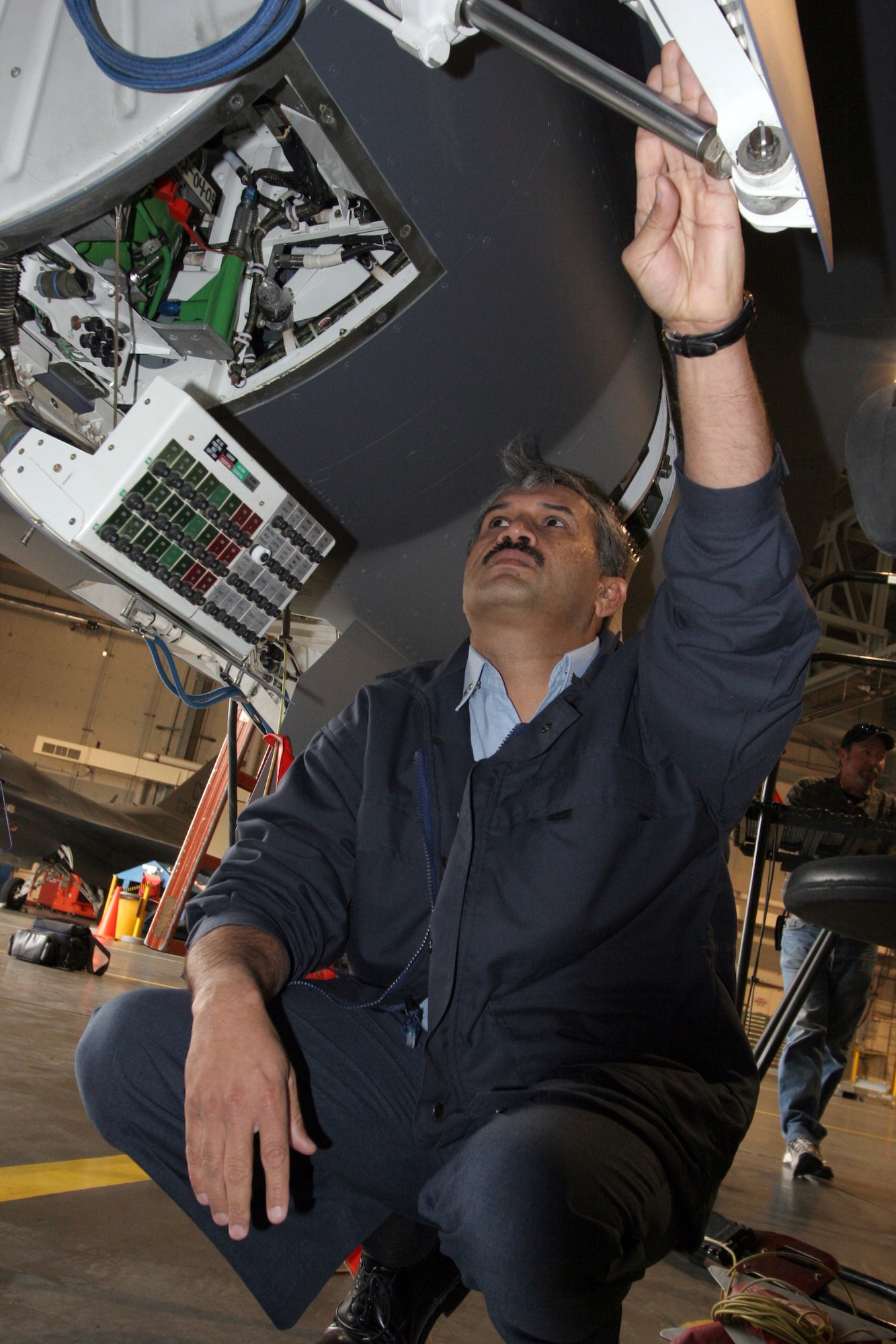 HILL AIR FORCE BASE, Utah (AFPN) -- Lt. Col. Mujahid Khan inspects the landing gear wheel well of one of the two F-16 Fighting Falcons being transferred to Pakistan. Two upgraded Air Force F-16s were delivered to the Pakistani air force Dec. 12. Colonel Mujahid Khan is the Pakistani F-16 support program liaison here. (U.S. Air Force photo by G. A. Volb)