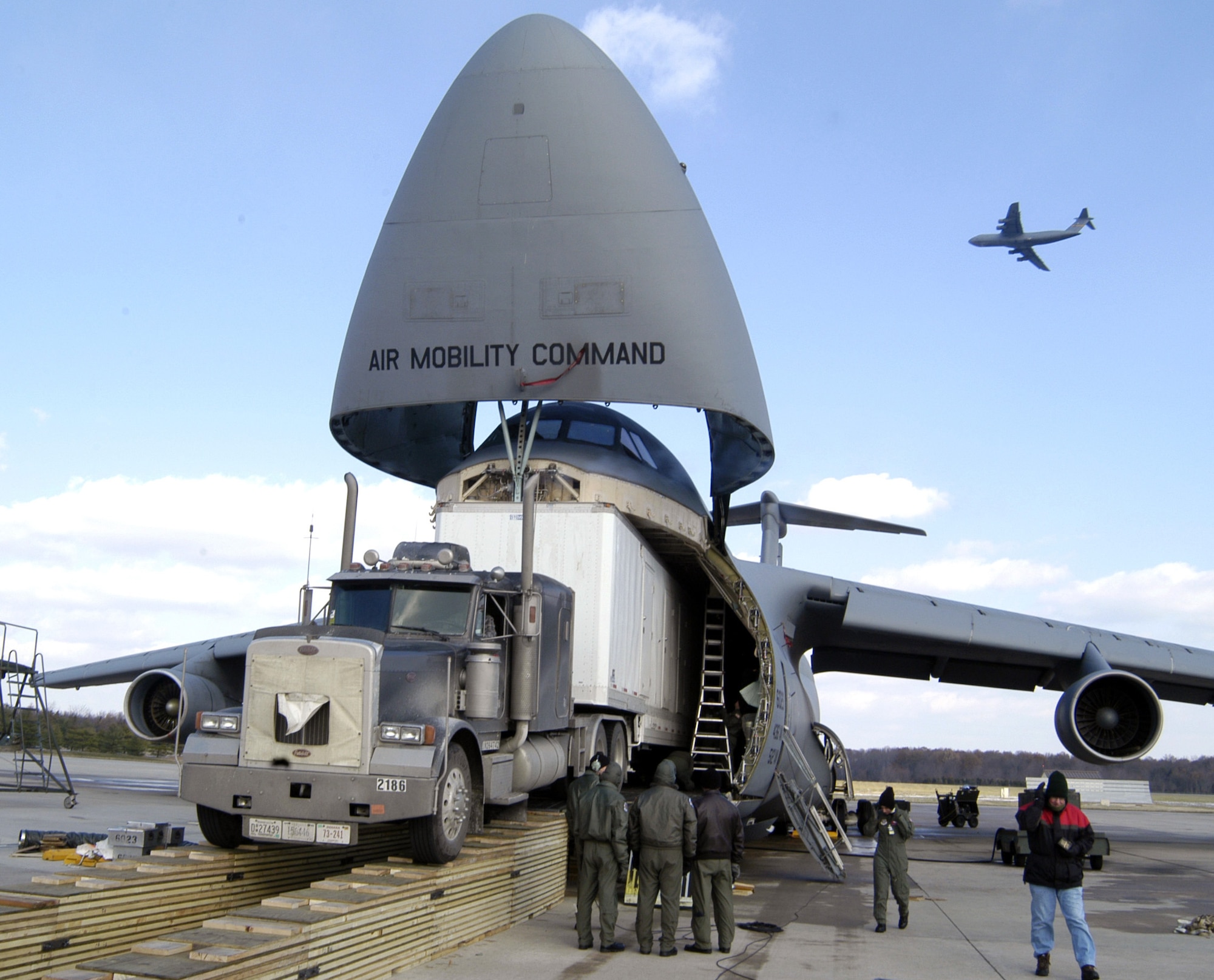 DOVER AIR FORCE BASE, Del. (AFPN) -- Airmen load the Aviation Combined Arms Tactical Trainer onto a C-5 Galaxy with the help of Army contractors. The trainer is an Army helicopter training simulator. Airmen from the 436th Aerial Port Squadron built a ramp specially designed to load the trainer on the transport. Before the ramp's creation, the only way to move the trainer was by ship, which took six to eight weeks to get to Soldiers in the field. (U.S. Air Force photo by Staff Sgt. James Wilkinson)