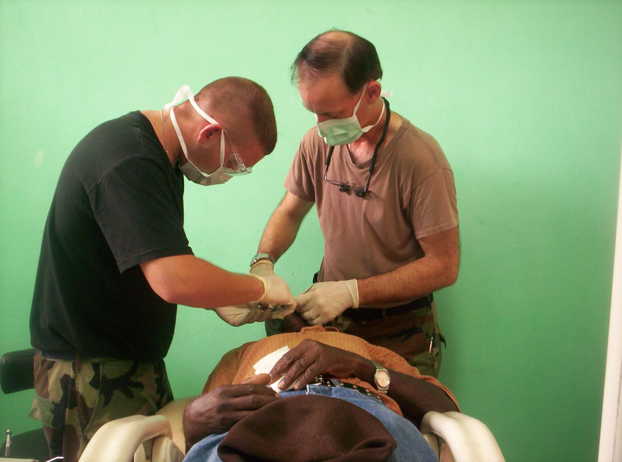 Maj. (Dr.) Craig Wisler, right, and Senior Airman John Dietz, both from the 434th Air Refueling Wing, Air Force Reserve Command, Grissom Air Reserve Base, Ind., provide dental care to a patient during a humanitarian mission to Grenada.