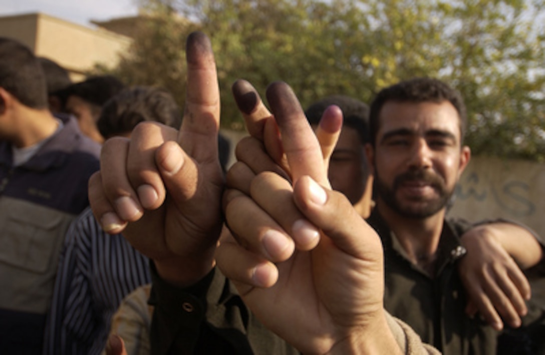 Iraqi men proudly show their inked-stained fingers after voting in Hayji, Iraq, on Dec. 15, 2005. Iraqi citizens are voting to elect Iraq's first free, permanent parliamentary government. 