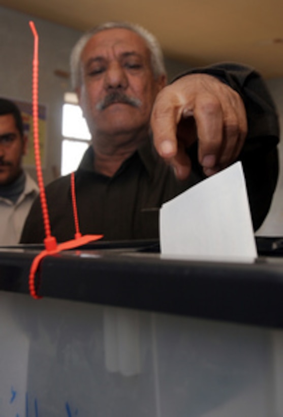 An Iraqi man drops his ballot into the ballot box as he votes in Fallujah, Iraq, on Dec. 15, 2005. Iraqi citizens are voting to elect Iraq's first free, permanent parliamentary government. 