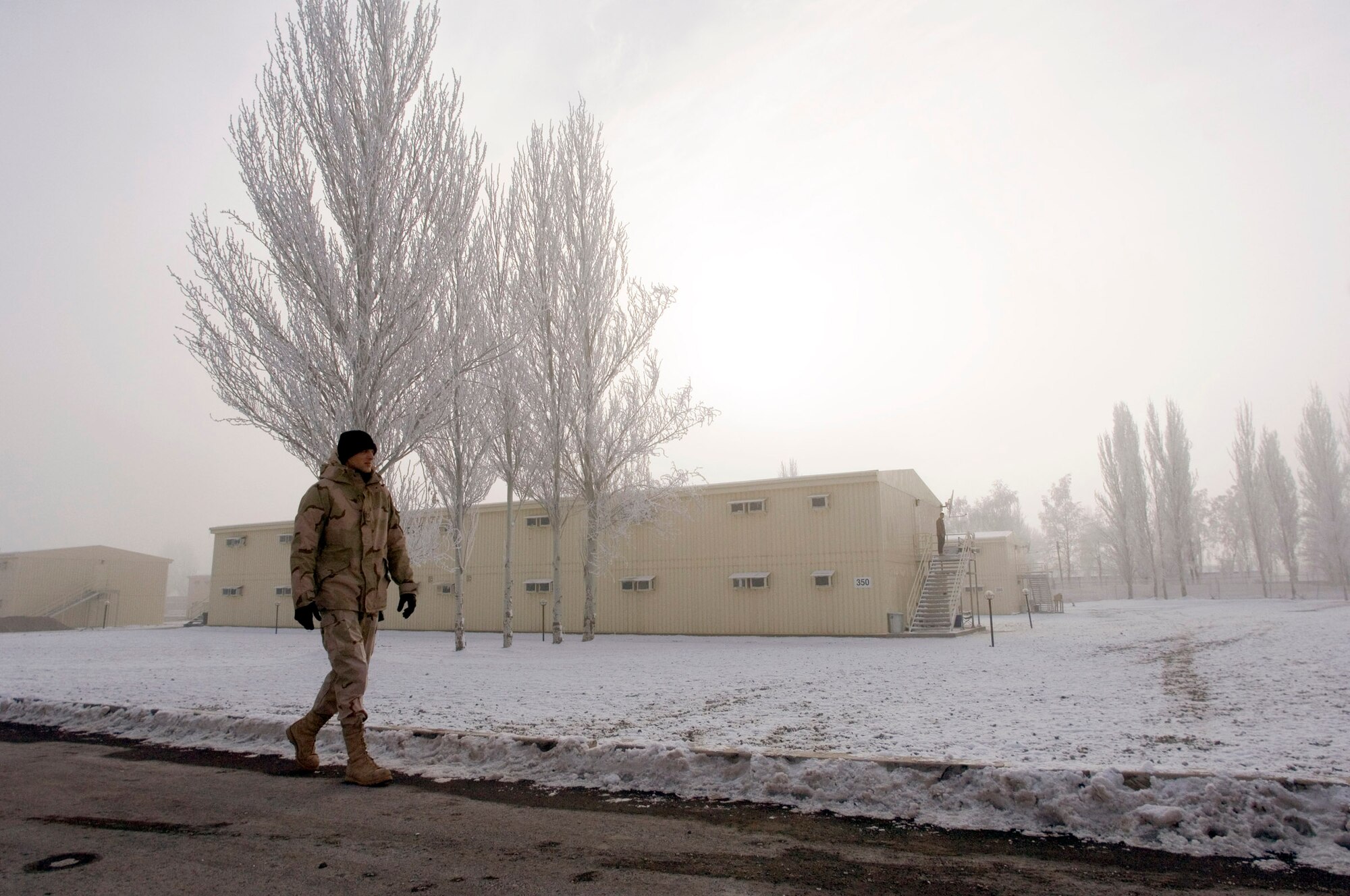 MANAS AIR BASE, Kyrgyzstan (AFPN) -- An Airman with the 376th Air Expeditionary Wing walks past the new dormitories here. The base houses nearly 7,000 people who move in and out of the region. (U.S. Air Force photo by Master Sgt. John E. Lasky)