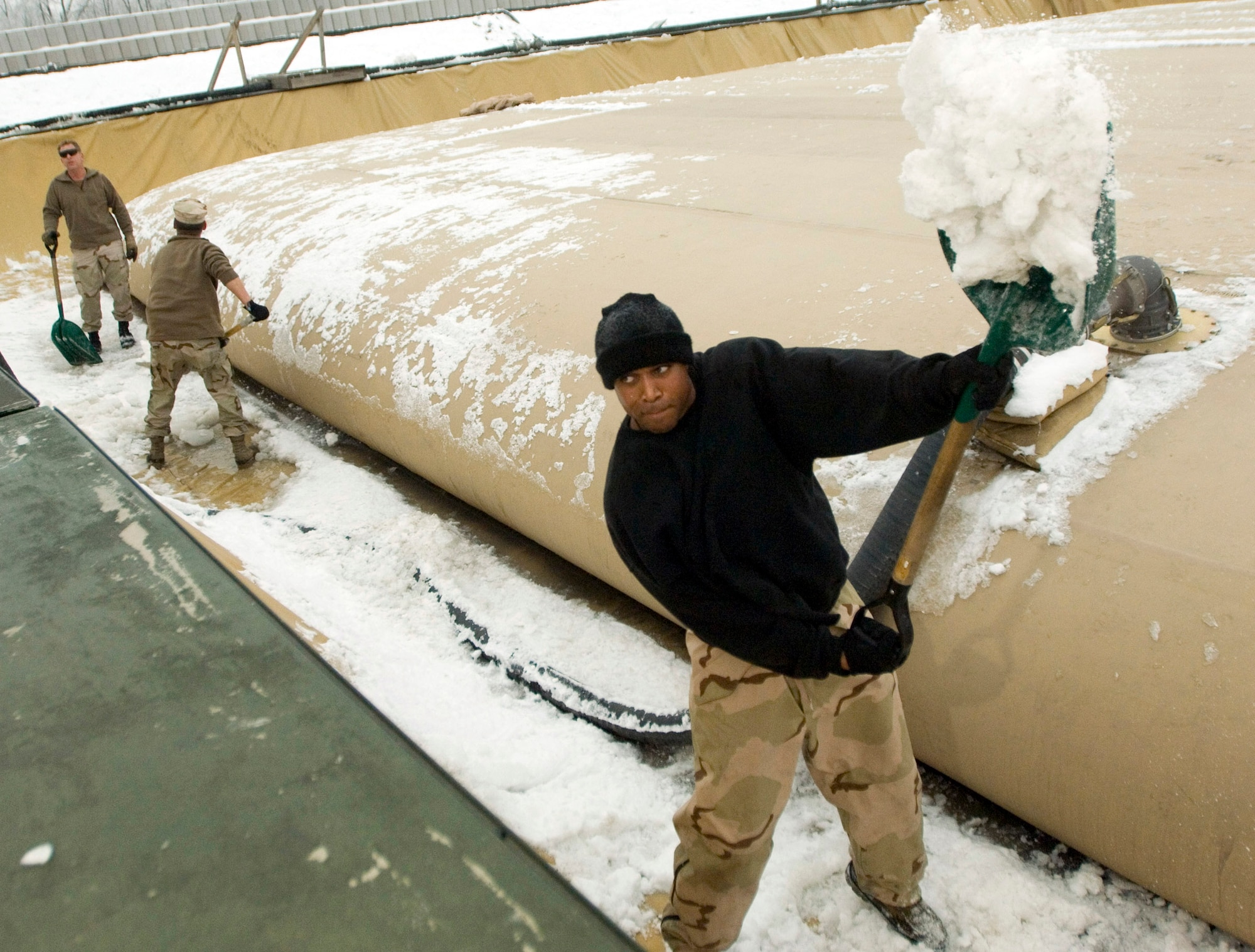 MANAS AIR BASE, Kyrgyzstan (AFPN) -- Staff Sgt. Anderson Matthews shovels snow from around a fuel bladder. The snow must be removed to reduce possible contamination if the bladder ruptures. Sergeant Anderson is a member of the 376th Expeditionary Logistics Squadron's petroleum, oil and lubricants section. He is deployed from Hurlburt Field Fla. (U.S. Air Force photo by Master Sgt. John E. Lasky)