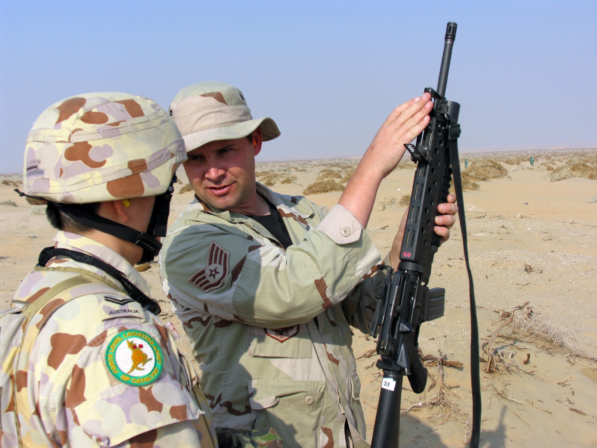 SOUTHWEST ASIA (AFPN) -- Staff Sgt. Richard Richardson explains a grenade launcher's targeting sights to an Australian soldier as part of a coalition weapons training exercise here. Sergeant Richardson is with the 386th Expeditionary Security Forces Squadron. He is deployed from the 435th Security Forces Squadron at Ramstein Air Base, Germany. (U.S. Air Force photo by Staff Sgt. Scott Campbell)