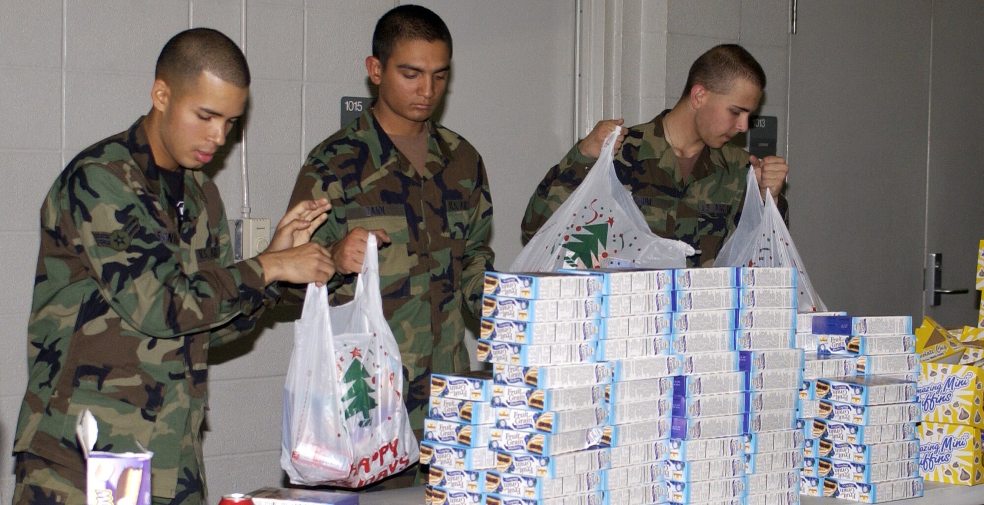 KEESLER AIR FORCE BASE, Miss. (AFPN) -- Airman 1st Class Carlos Santiago (left), Airman Basic Hasan Zaida and Airman Basic Matthew Saum pack goodie bags for children at the Biloxi Fire Station. The Airmen, with the 336th Training Squadron, assisted with Operation Win for Kids. (U.S. Air Force photo by Kemberly Groue)