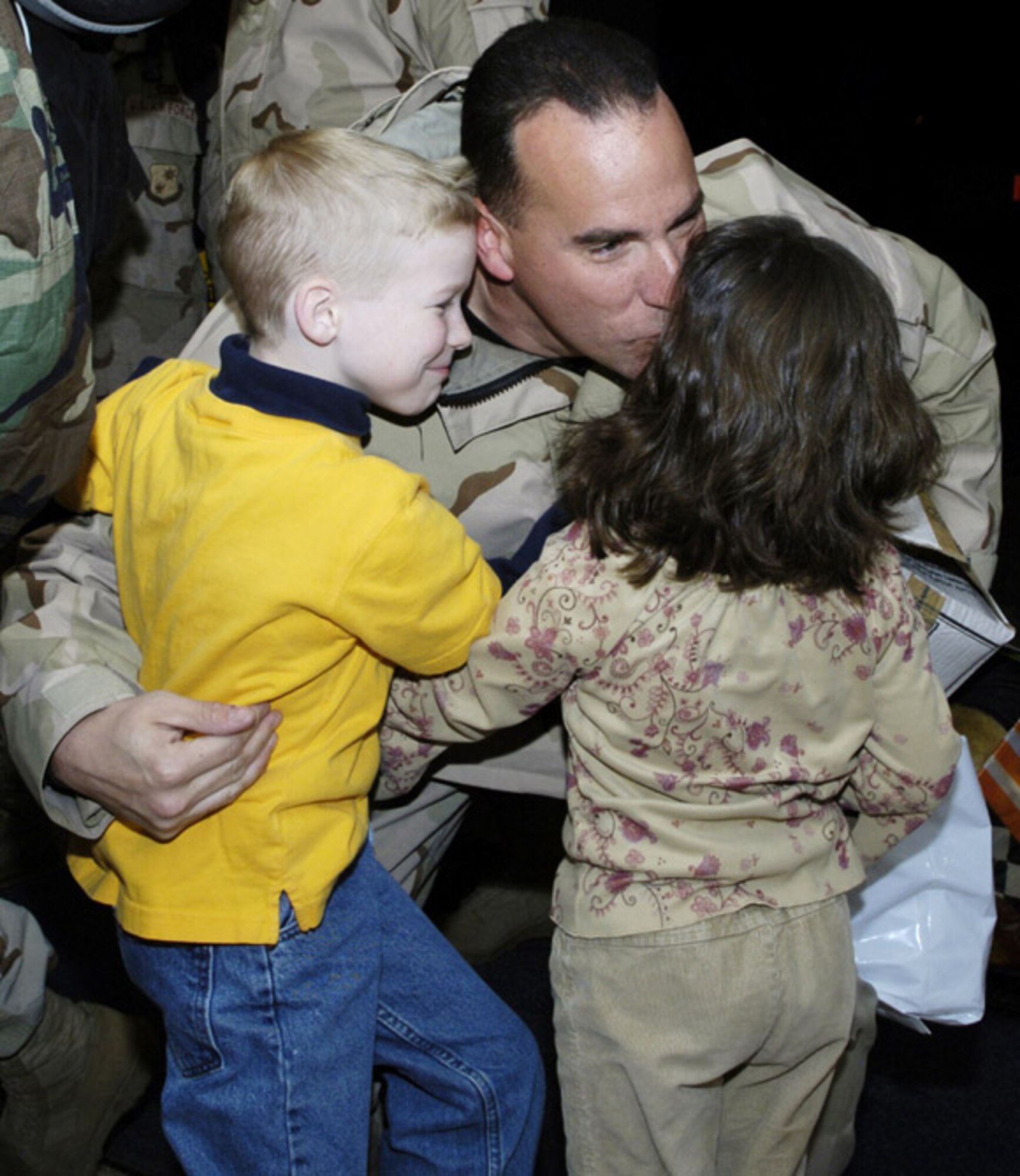 MCGUIRE AIR FORCE BASE, N.J. (AFPN) -- Tech. Sgt. Jeffrey Mitchell kisses his 6-year-old daughter, Silkie, and hugs his 8-year-old son, Daniel, when he returned from Pakistan. Sergeant Mitchell returned home after two months supporting Pakistan earthquake relief efforts. (U.S. Air Force photo by Kenn Mann)