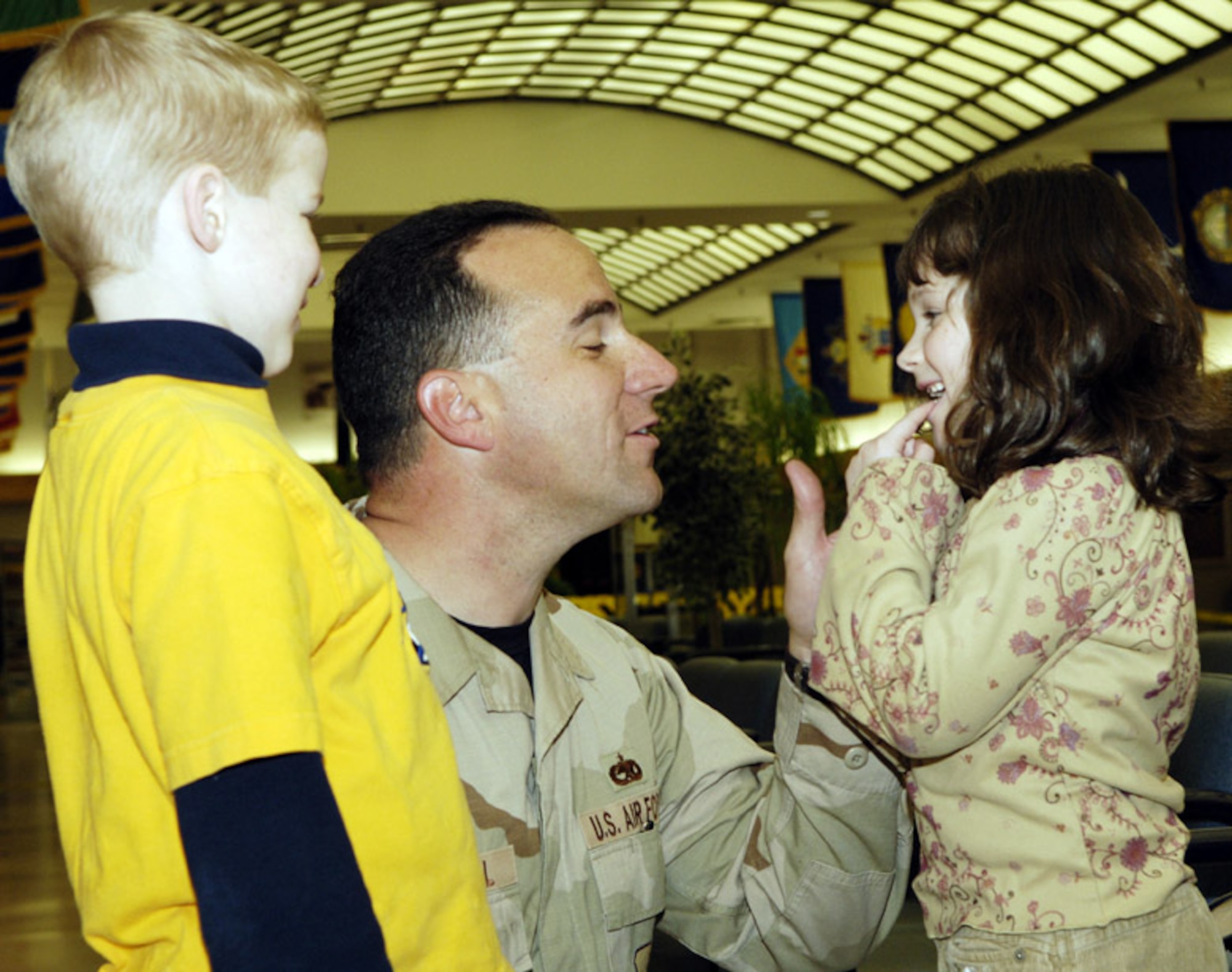 MCGUIRE AIR FORCE BASE, N.J. (AFPN) -- Tech. Sgt. Jeffrey Mitchell checks out his 6-year-old daughter Silkie's new tooth with his 8-year-old son, Daniel. Sergeant Mitchell returned from Pakistan after two months supporting earthquake relief efforts. (U.S. Air Force photo by Kenn Mann)