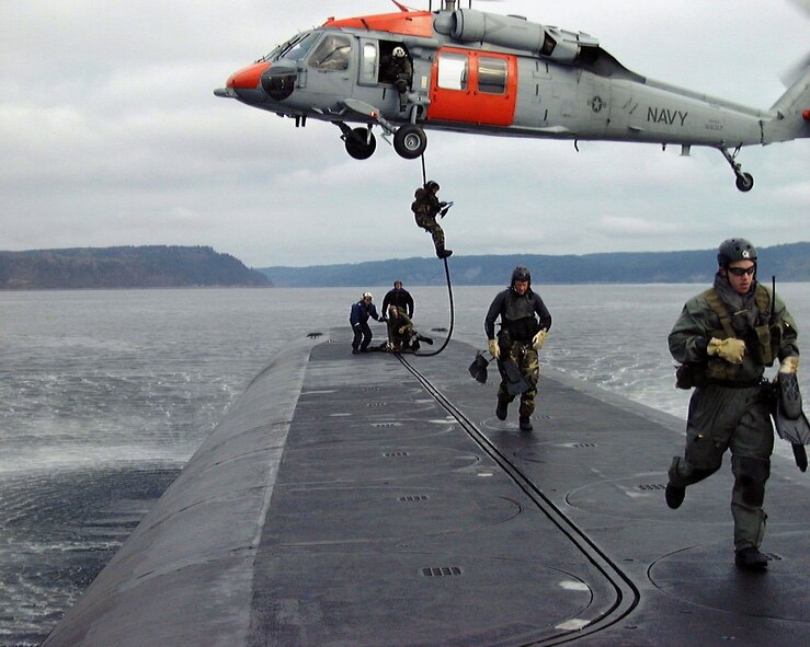Air Force special operations forces from the 22nd and 23rd Special Tactics Squadrons fast rope onto the deck of USS Alabama (SSBN 731) in the Pacific Ocean during a recent exercise to test special operations infiltration and rescue tactics. The joint effort also tests the capabilities of the SSGN class submarines entering service next year. The SSGN class submarines are being converted from ballistic missile submarines to guided missile submarines with new capabilities.  US Navy photo by FTCM (SS) Daniel J. Niclas