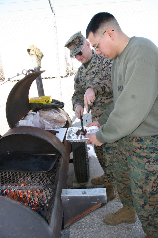 NAVAL AIR STATION-JOINT RESERVE BASE FORT WORTH, Texas (Dec. 15, 2005) - Marine Air Control Squadron 24, Detachment ?A? acting supply, logistics and embark chief, Staff Sgt. Eugene Willette and aviation supply clerk, Sgt. Jorge A. Echeverria grill up a Texas-style meal of steak fajitas, complete with Willette?s secret recipe of guacamole and pico de gallo, to sell to servicemembers on board Naval Air Station-Joint Reserve Base Fort Worth, Texas for a fund raiser to support the homecoming of fellow MACS-24 Marines returning from Iraq this coming February.