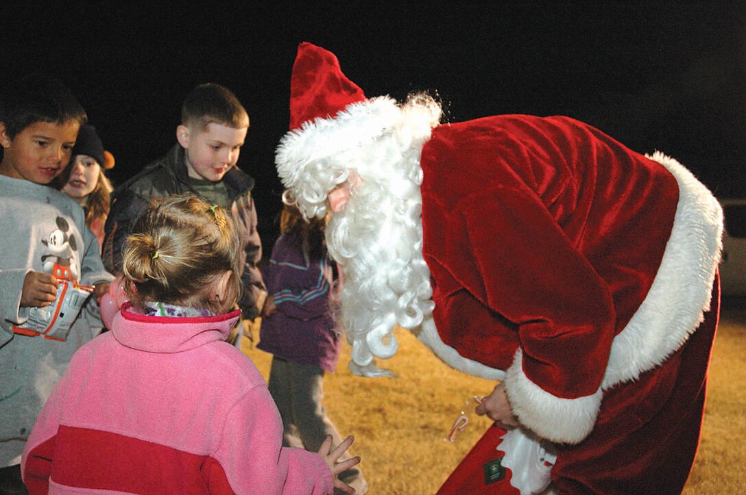 Santa Claus talks to a group of children at the Ho, Ho, Ho Down Dec. 16 on the station parade field. Escorted to the event by the Marine Corps Air Station Yuma Fire Department in a fire truck, Santa listened to the children?s Christmas wishes while handing out candy canes. Also in costume were Snookie, Cupcake and Chatty Chia, three clowns who provided children with face painting and balloon creations throughout the night.