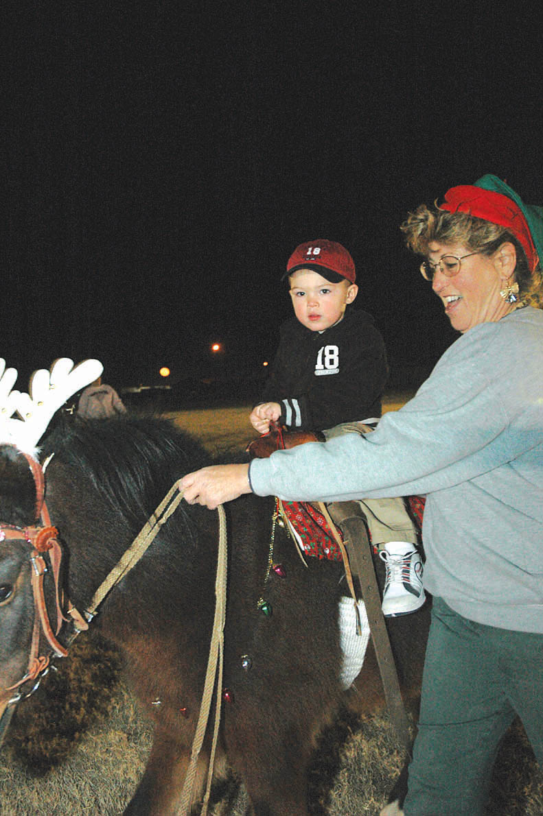Anthony Lacovara, 2, takes a ride on Colorin under the close supervision of Carrie Tidaback, owner of Party Pony Rides with Colorin, at the Ho, Ho, Ho Down Dec. 16 on the station parade field. The event featured attractions for the whole family, ranging from pony rides and face painting to tractor rides and raffles throughout the night. Free refreshments were provided in the form of cotton candy, popcorn and soda.