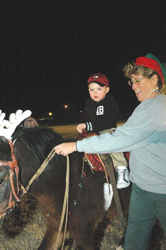 Anthony Lacovara, 2, takes a ride on Colorin under the close supervision of Carrie Tidaback, owner of Party Pony Rides with Colorin, at the Ho, Ho, Ho Down Dec. 16 on the station parade field. The event featured attractions for the whole family, ranging from pony rides and face painting to tractor rides and raffles throughout the night. Free refreshments were provided in the form of cotton candy, popcorn and soda.