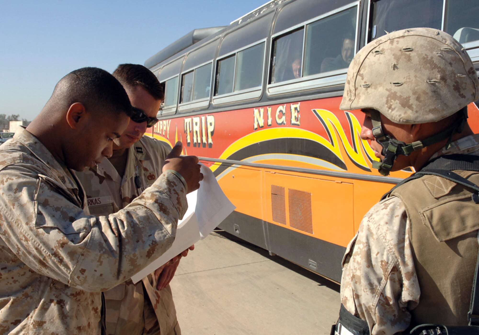 BAGHDAD, Iraq (AFPN) -- Marine Staff Sgt. Shawn Baker (left) reviews a boarding roster with Capt. Robert Farkas as another Marine looks on during the Iraqi elections.  Sergeant Baker is assigned to the II Marine Expeditionary Force, and Captain Farkas is assigned to the 447th Expeditionary Logistics Readiness Squadron. (U.S. Air Force photo by Master Sgt. Randy L. Mitchell) 