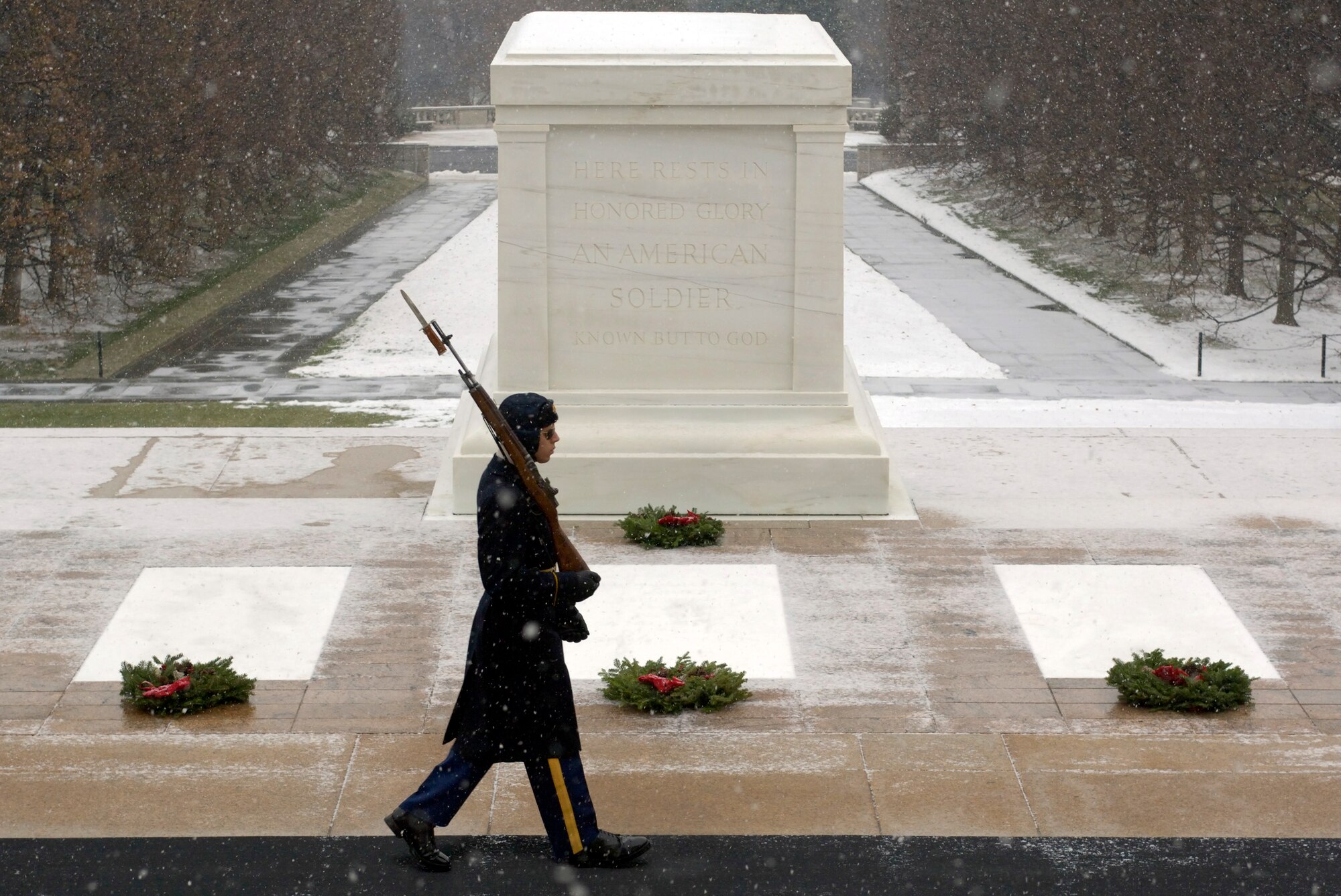 ARLINGTON, Va. (AFPN) - An Arlington Honor Guardsman walks his post past the tomb of the Unknown Soldier.  The tomb was one of more than 5,000 headstones decorated by volunteers.  The 14th annual wreath laying event is the result of Worcester Wreath Company's owner Morrill Worcester's, childhood dream of doing something to honor those laid to rest in the national cemetery. (U.S. Air Force photo by Master Sgt. Jim Varhegyi)