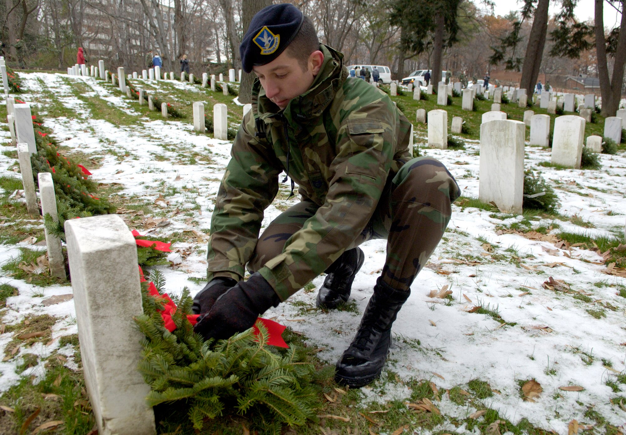 ARLINGTON, Va. (AFPN) -- Tech. Sgt. Scott Glassic places a wreath on a headstone.  He was one of hundreds of volunteers who gathered at Arlington National Cemetery to place more than 5,000 donated Christmas wreaths. The 14th annual wreath laying event is the result of Worcester Wreath Company's owner Morrill Worcester's, childhood dream of doing something to honor those laid to rest in the national cemetery. (U.S. Air Force photo by Master Sgt. Jim Varhegyi)