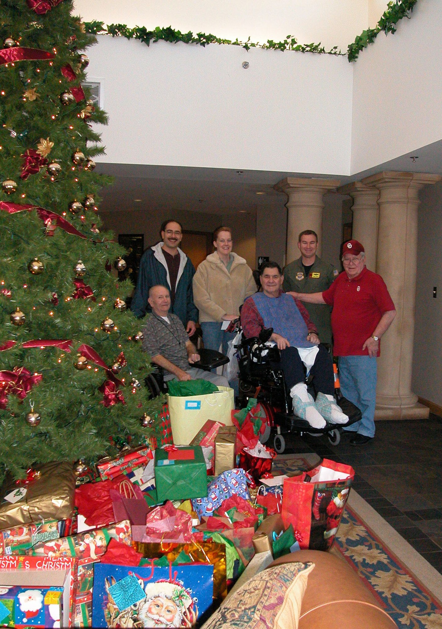 Air Force Reserve 'Angels' (Back row left to right) SMSgt. Bob Gaspar, SSgt. Colleen Rehm and Maj. Jimmy Wolfe pose with residents of the Norman Veterans Center during 2004.  Reservists from the 507th Air Refueling Wing and 513th Air Control Group surpassed last year's 179 gifts to provide 254 gifts for center residents in 2005 year.  A party for the veterans will be held December 22.