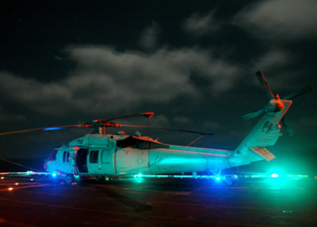 Flight deck lights illuminate a Navy SH-60 Seahawk helicopter as it sits on the deck of the USS Tarawa (LHA 1) on Dec. 11, 2005. The Tarawa and its embarked Expeditionary Strike Group 1 are currently conducting maritime security operations in the Persian Gulf. 