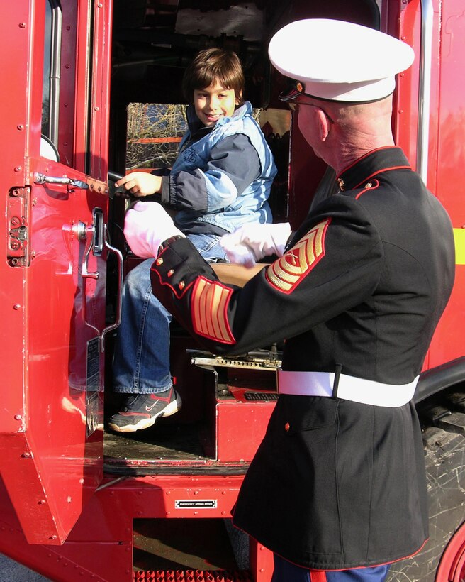 STUTTGART, Germany (Dec. 20, 2005) Master Sgt. Robert Hartman, communications chief, U.S. Marine Corps Forces Europe, shows a student how to drive a fire truck during a recent Christmas celebration here.  Santa along with Marines from MARFOREUR arrived on the fire truck and attended the celebration, bringing Christmas stockings and taking pictures of the students with Santa at the Schule für Körperbehindertemade, a handicapped children's school in Stuttgart, Germany.