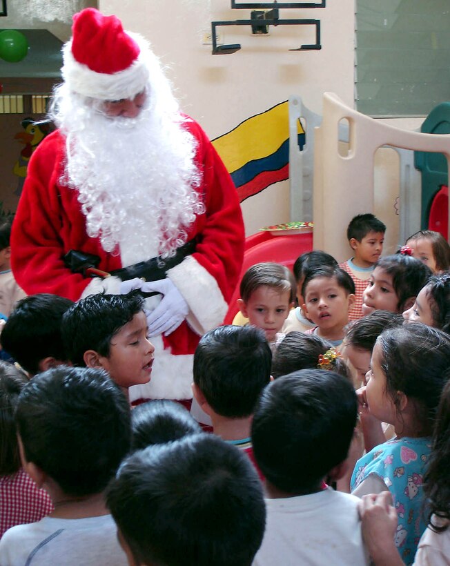 MANTA AIR BASE, Ecuador (AFPN) -- Santa Claus listens to children sing after they received toys at an elementary school. Airmen will be giving 1,800 toys to children at schools, hospitals and other organizations for the holidays. (U.S. Air Force photo)