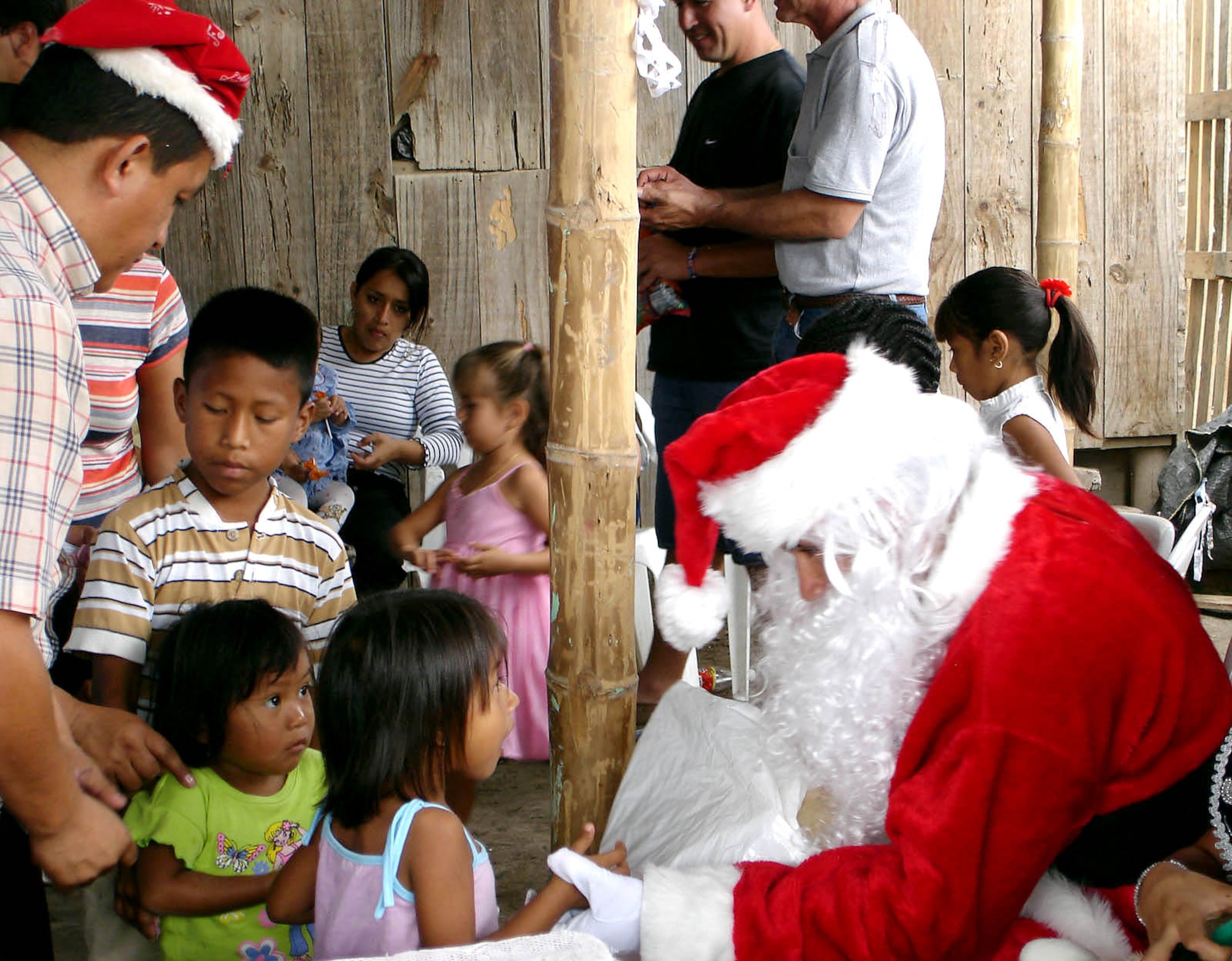 MANTA AIR BASE, Ecuador -- Santa Claus hands out toys and candy to children at an elementary school.  Airmen will be giving 1,800 toys to children at schools, hospitals and community organizations for the holidays. (U.S. Air Force photo)