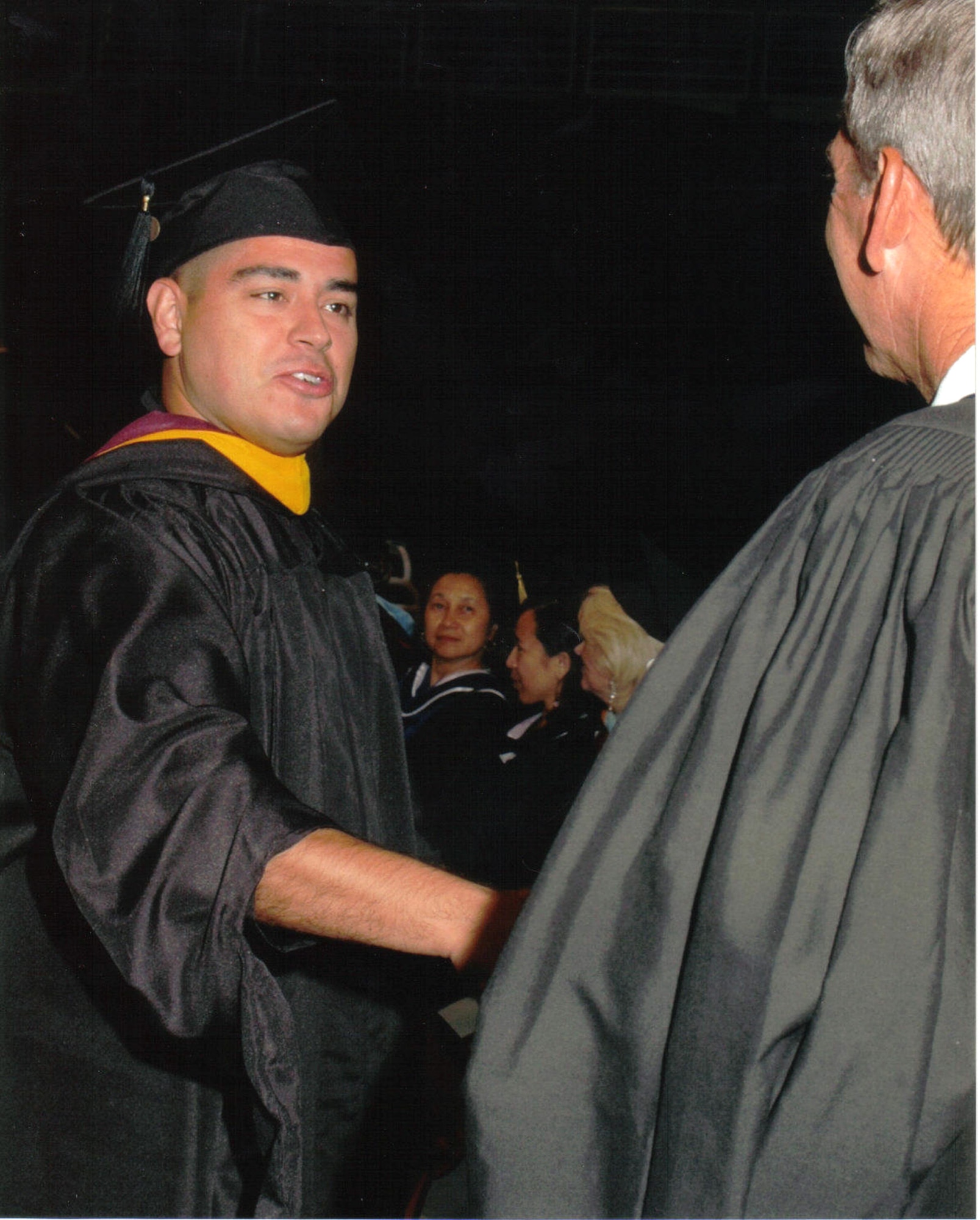 PHOENIX (AFPN) -- Tech. Sgt. Rodolfo "Rudy" Flores, 8th Aircraft Maintenance Squadron security manager, receives his masters degree in computer information systems from the University of Phoenixs dean July 30. It was the second graduate degree for the sergeant. (U.S. Air Force photo) 